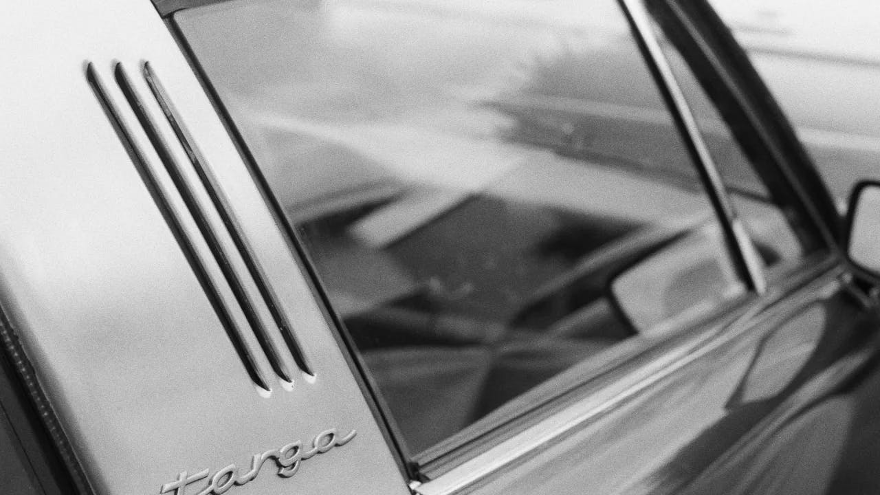 High-contrast black and white photograph of a Porsche Targa captured on Ilford HP5+ film, featuring a sleek and timeless design with a classic and vintage feel.